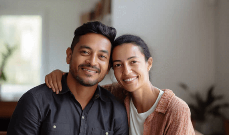 Australian couple sitting on couch in living room contemplating genetic testing